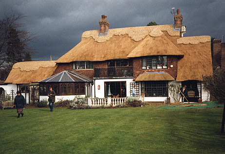 Rethatched house in water reed with vastly ornate ridge